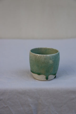 Speckled latte cup in ocean