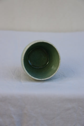 Speckled latte cup in ocean