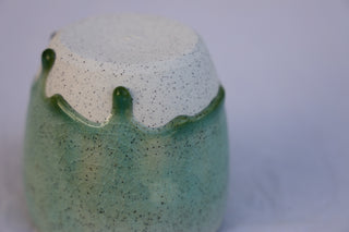 Speckled latte cup in ocean